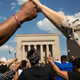 People hold hands during a rally led by faith leaders in front of Baltimore’s City Hall May 3, 2015, calling for justice in response to the death of Freddie Gray.
Andrew Burton/Getty Images